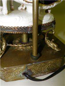   couple with a brass ornate dolphin feet base. This royal figural lamp